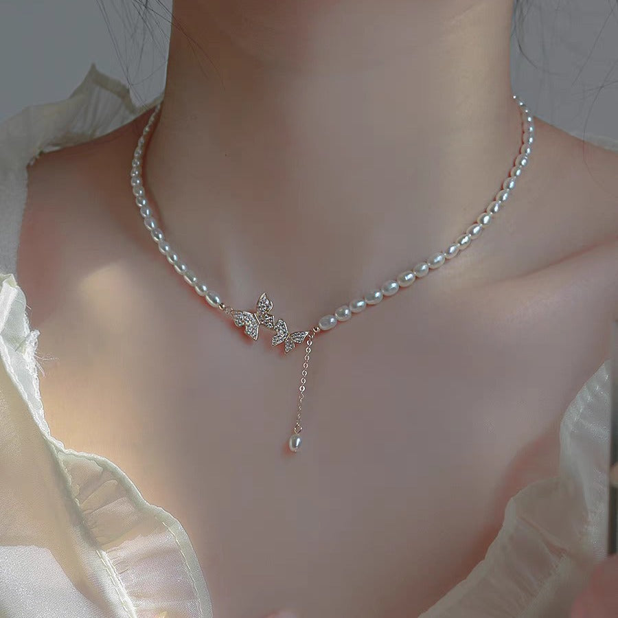 Freshwater pearl choker with pavé butterflies and a pearl drop, worn at the collarbone