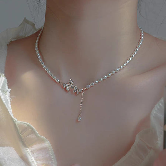Freshwater pearl choker with pavé butterflies and a pearl drop, worn at the collarbone