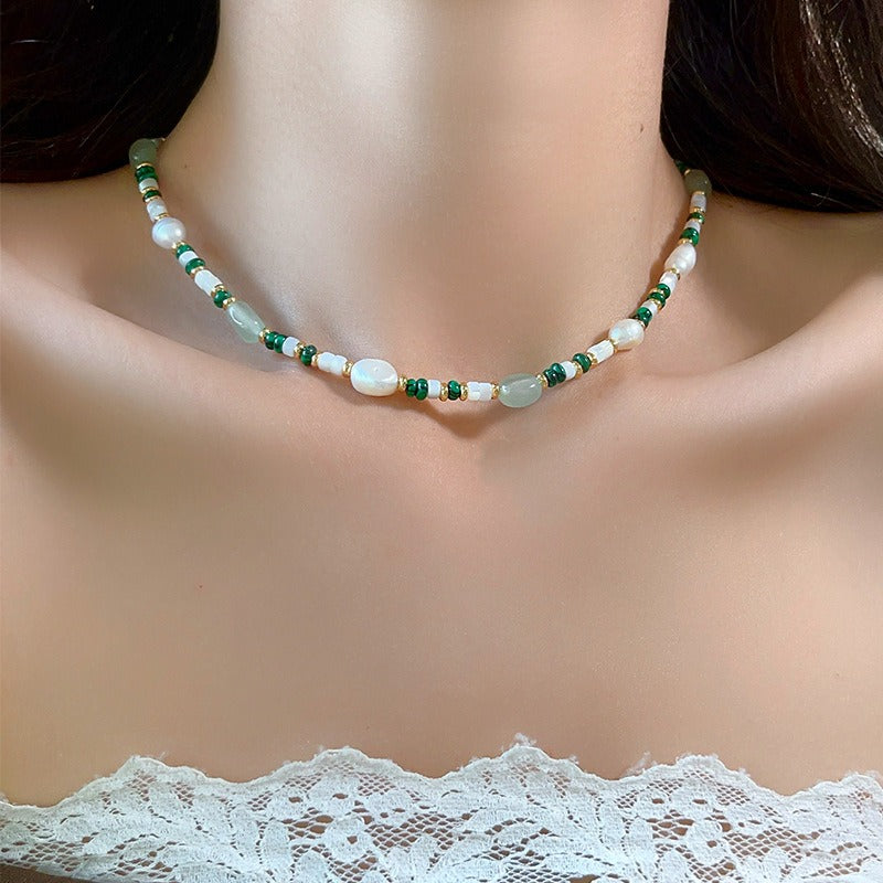 Aventurine and pearl necklace worn at the collarbone