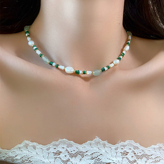 Aventurine and pearl necklace worn at the collarbone