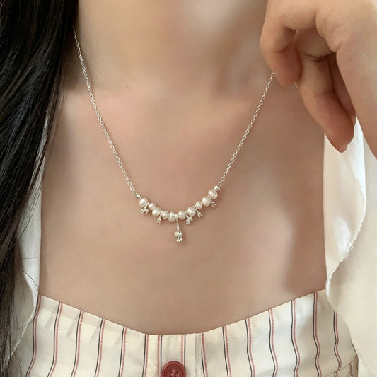 Tulip freshwater pearl necklace worn at the collarbone
