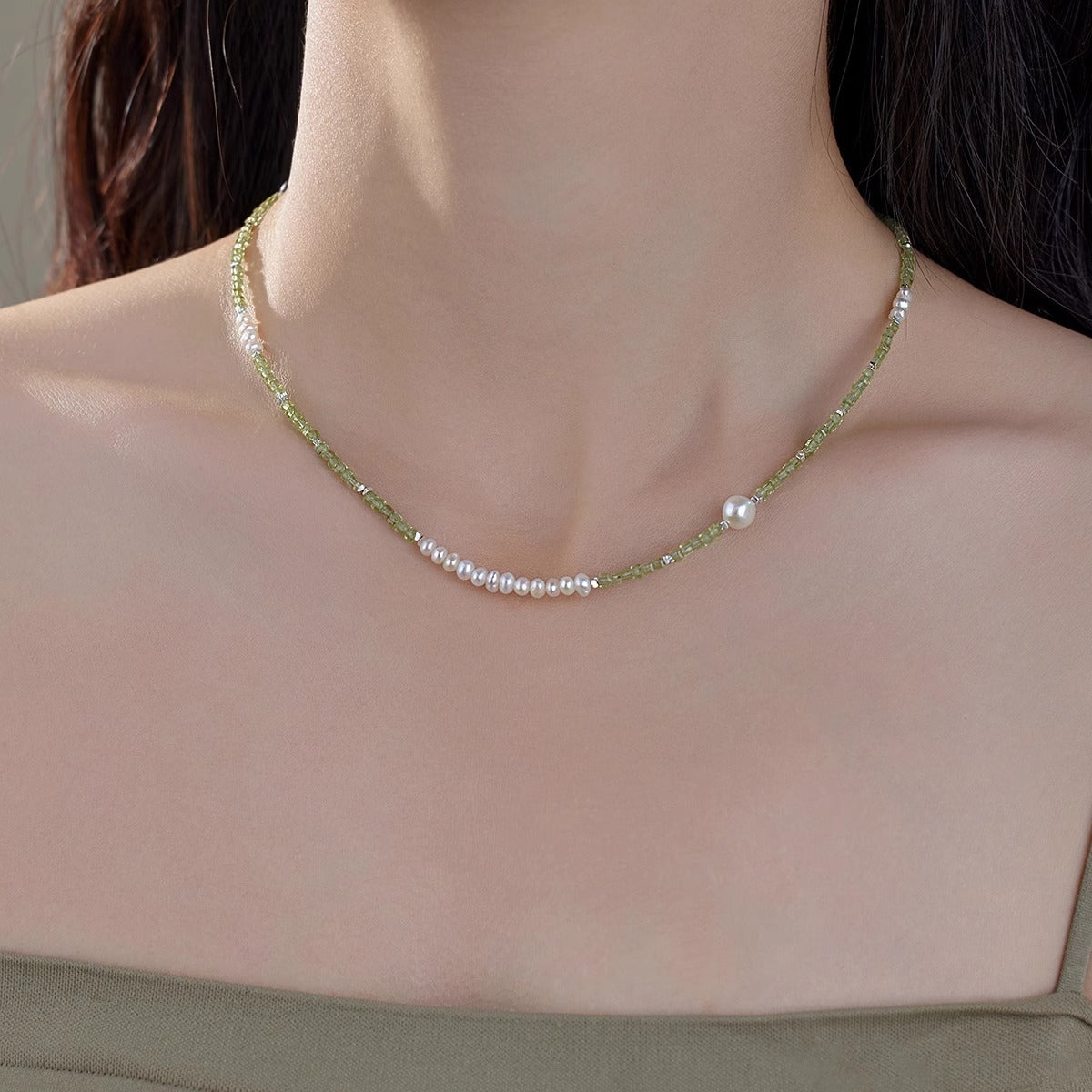 Peridot bead and freshwater pearl necklace worn at the collarbone