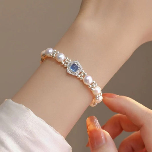 Blue stone halo pearl bracelet worn on the wrist