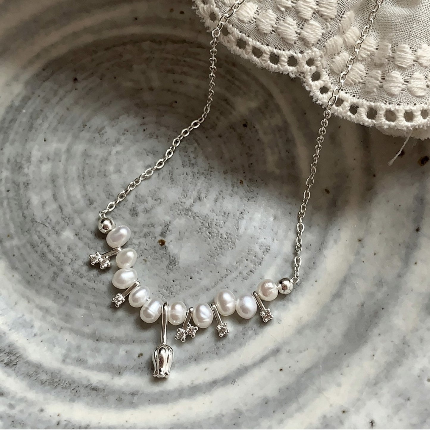 Tulip pearl necklace with crystal stars in a ceramic bowl