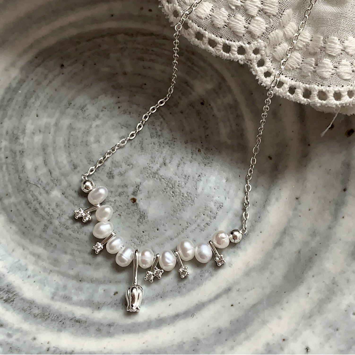 Tulip pearl necklace with crystal stars in a ceramic bowl