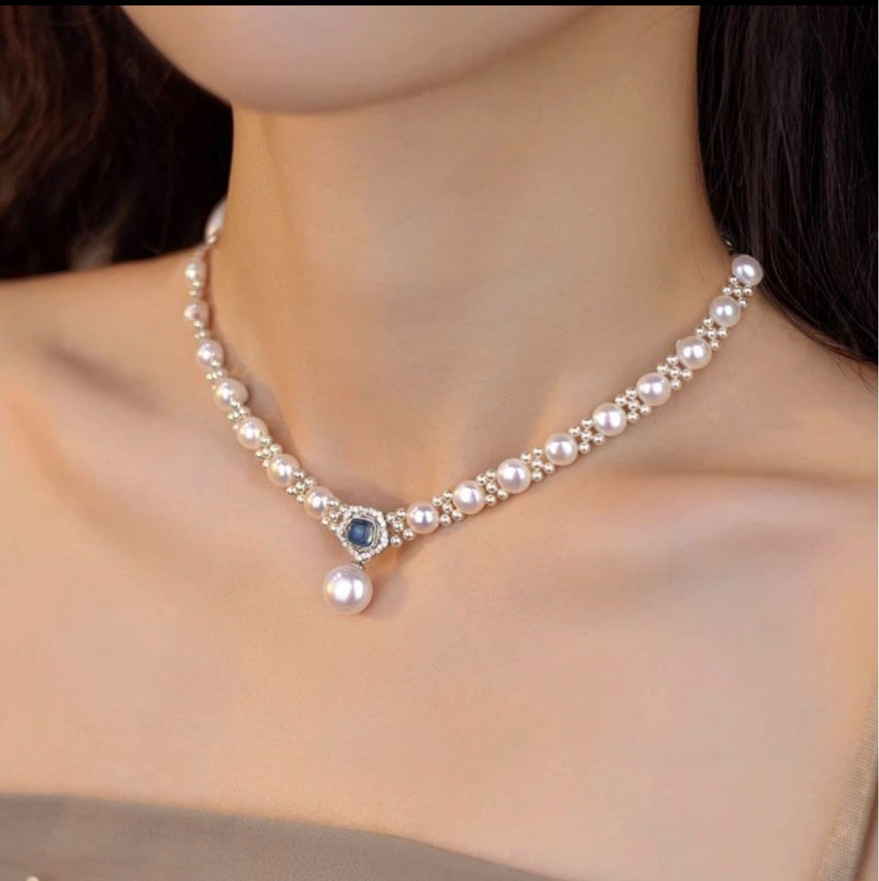 Blue stone pearl drop necklace on a model