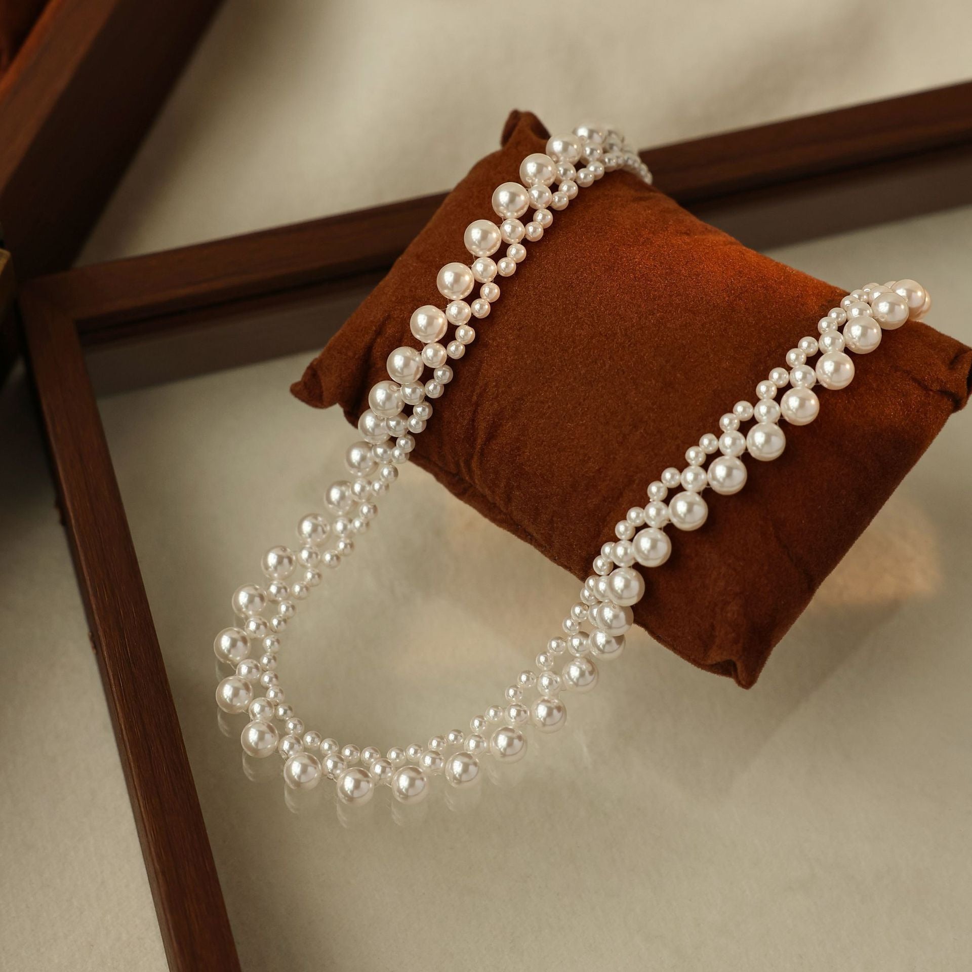 Woven pearl choker on a velvet cushion