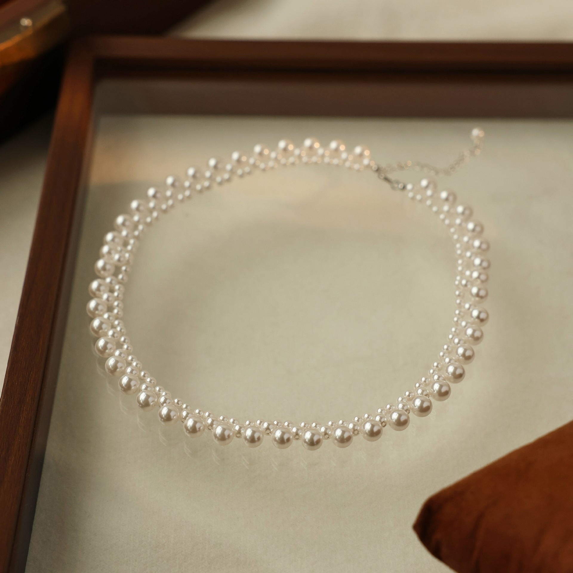 Woven pearl choker laid in a circle, clasp visible