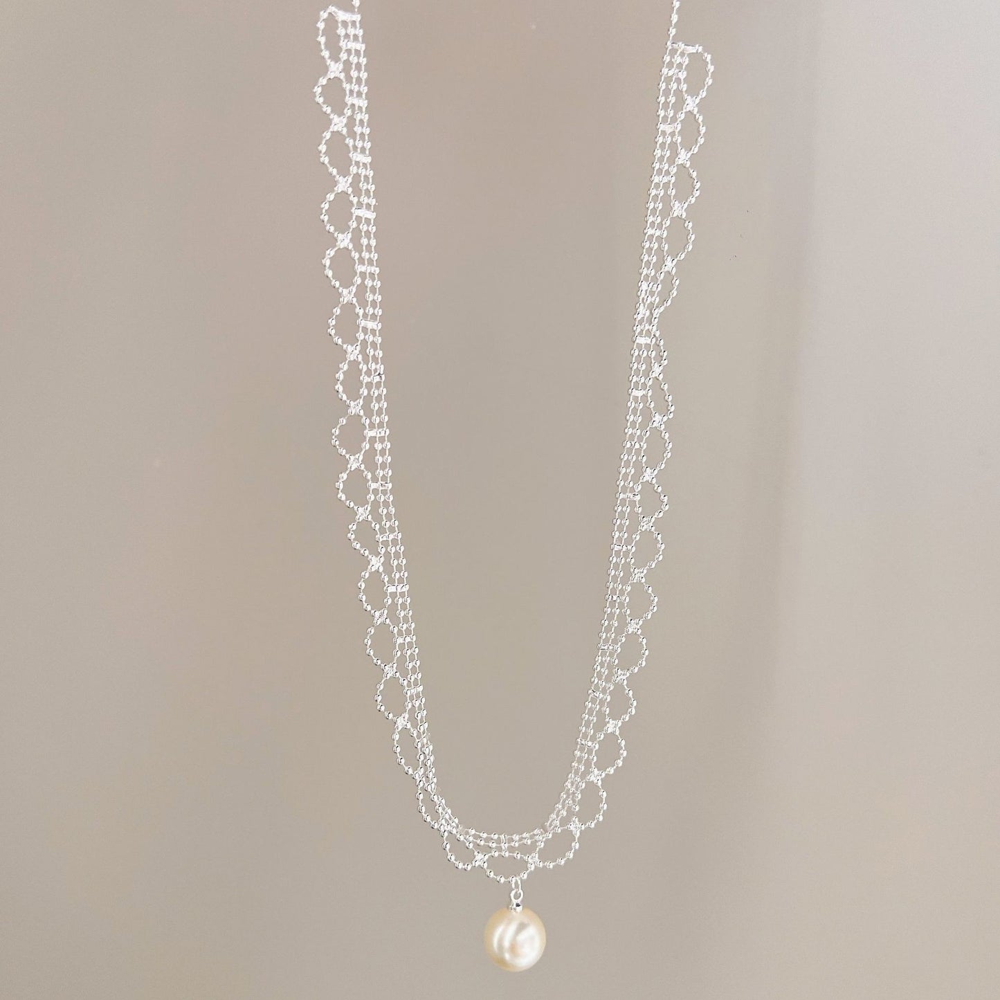 Silver lace pearl drop necklace hanging view