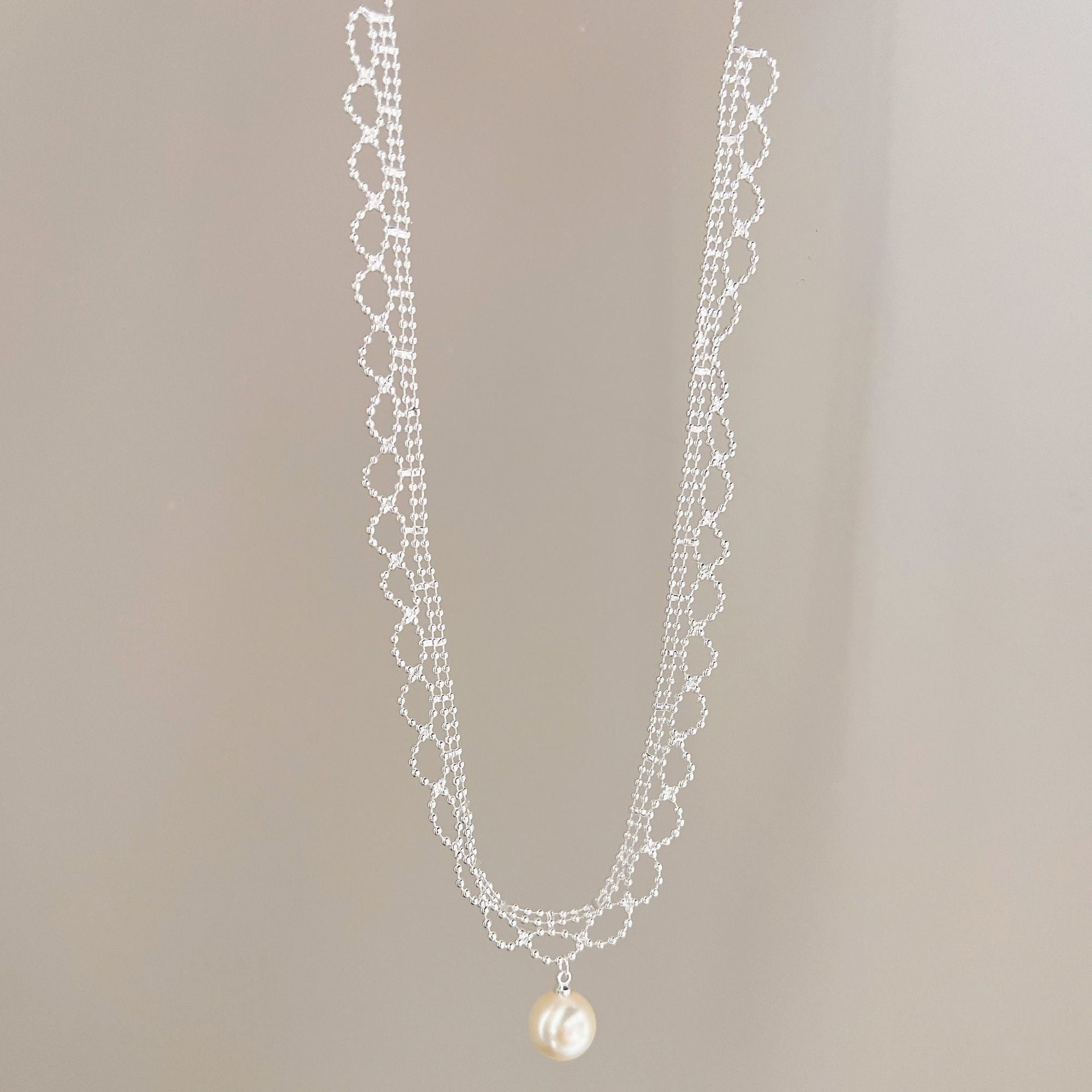 Silver lace pearl drop necklace hanging view